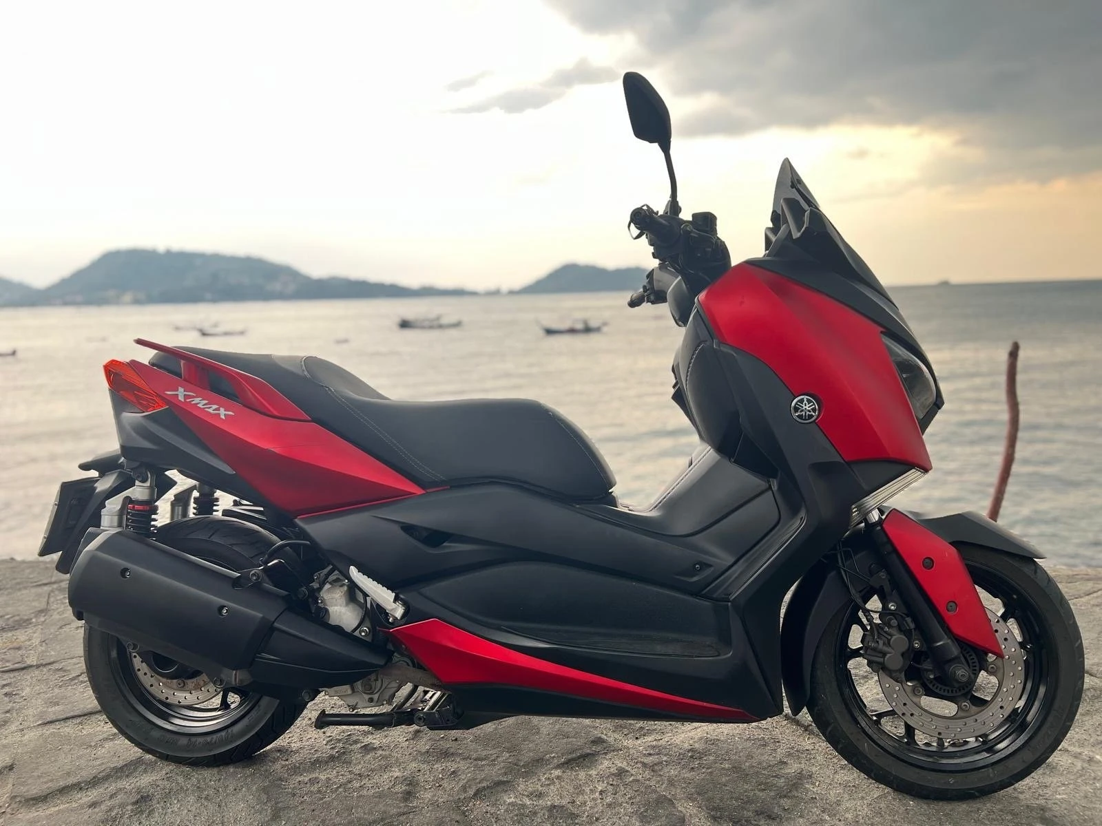 Red scooter overlooking the sea at sunset
